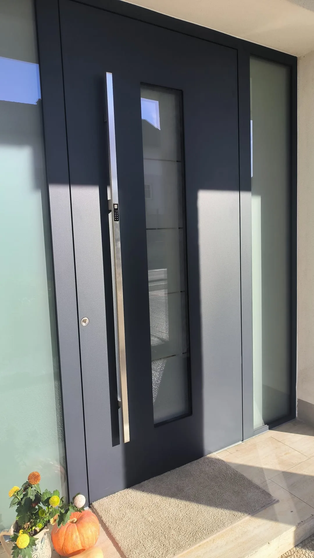 Anthrazitfarbene Haustür mit Glasstreifen, langem Edelstahlgriff und Ziffernblock