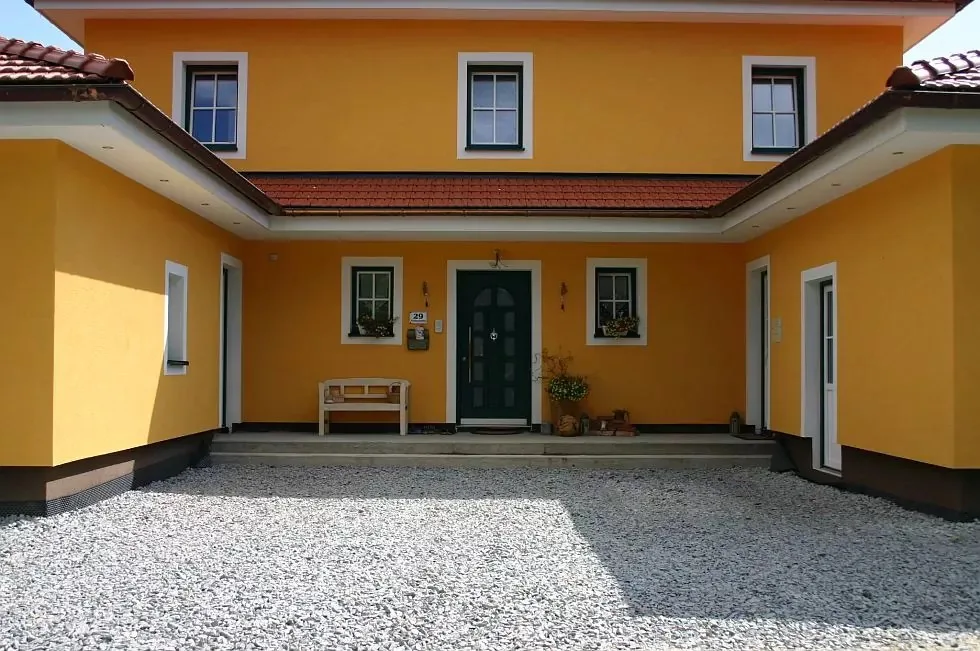 Gelbes Haus mit Innenhof, neuen Fenstern und grüner Haustür