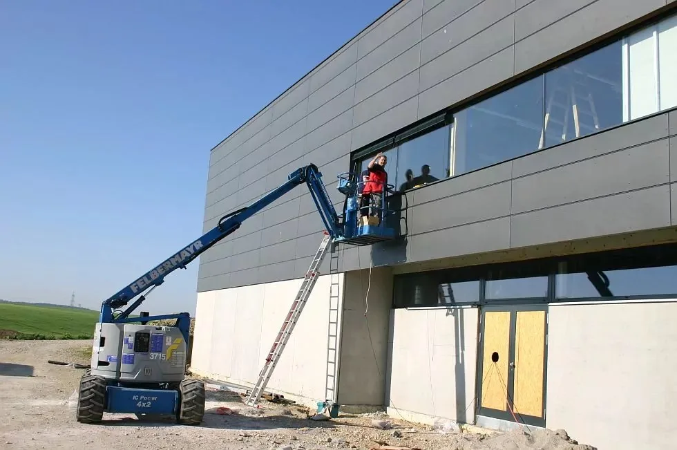 Montage an einem Gewerbebau mit Hubsteiger an der Fensterfront