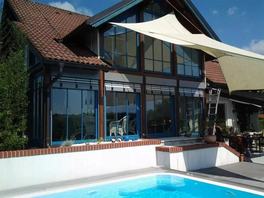 Haus mit großen Glasflächen, Raffstores, Sonnensegel und Pool