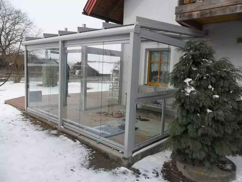 Verglaste Terrasse an einem Haus im Schnee